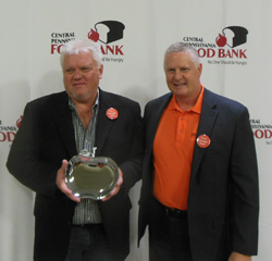 John Meckley, left, accepts the  Innovative Partner Award on behalf  of Milton Bicentennial-Conagra Brands  at Thursday's  Hunger Action Month breakfast held by the Central Pennsylvania Food Bank. At right is Joe Arthur, food bank executive director. MIKE REUTHER/Sun-Gazette
